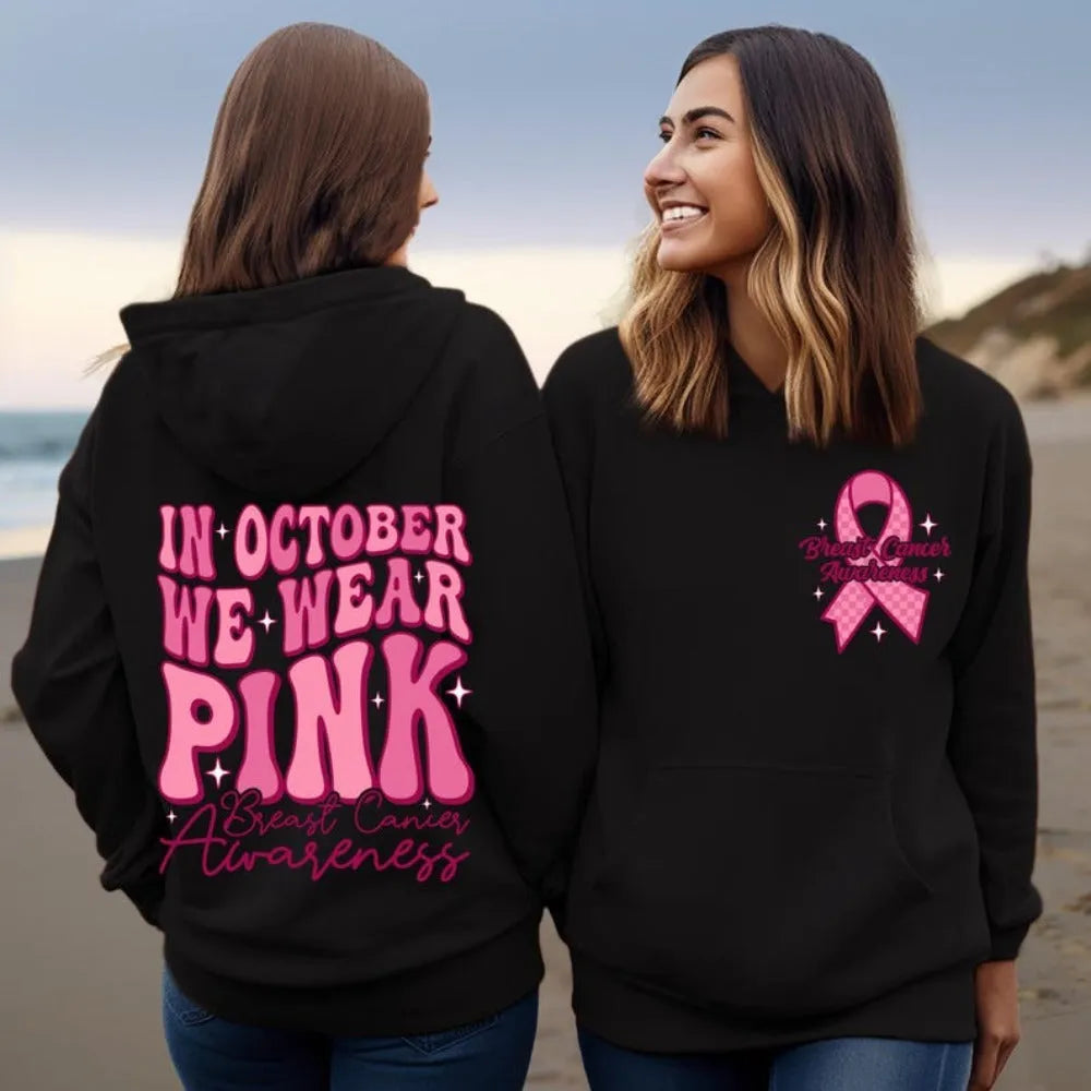 Pink breast cancer awareness hoodie with retro pattern and side pocket on a hanger.