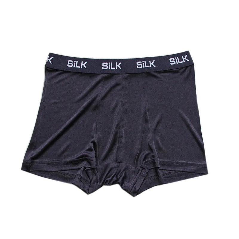 Men's loose-fit silk shorts in navy blue, shown on a mid-waist.