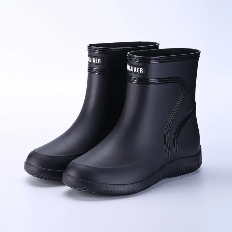 Men's mid-top PVC rain boots in black with green detailing, tassel decoration, and non-slip sole
