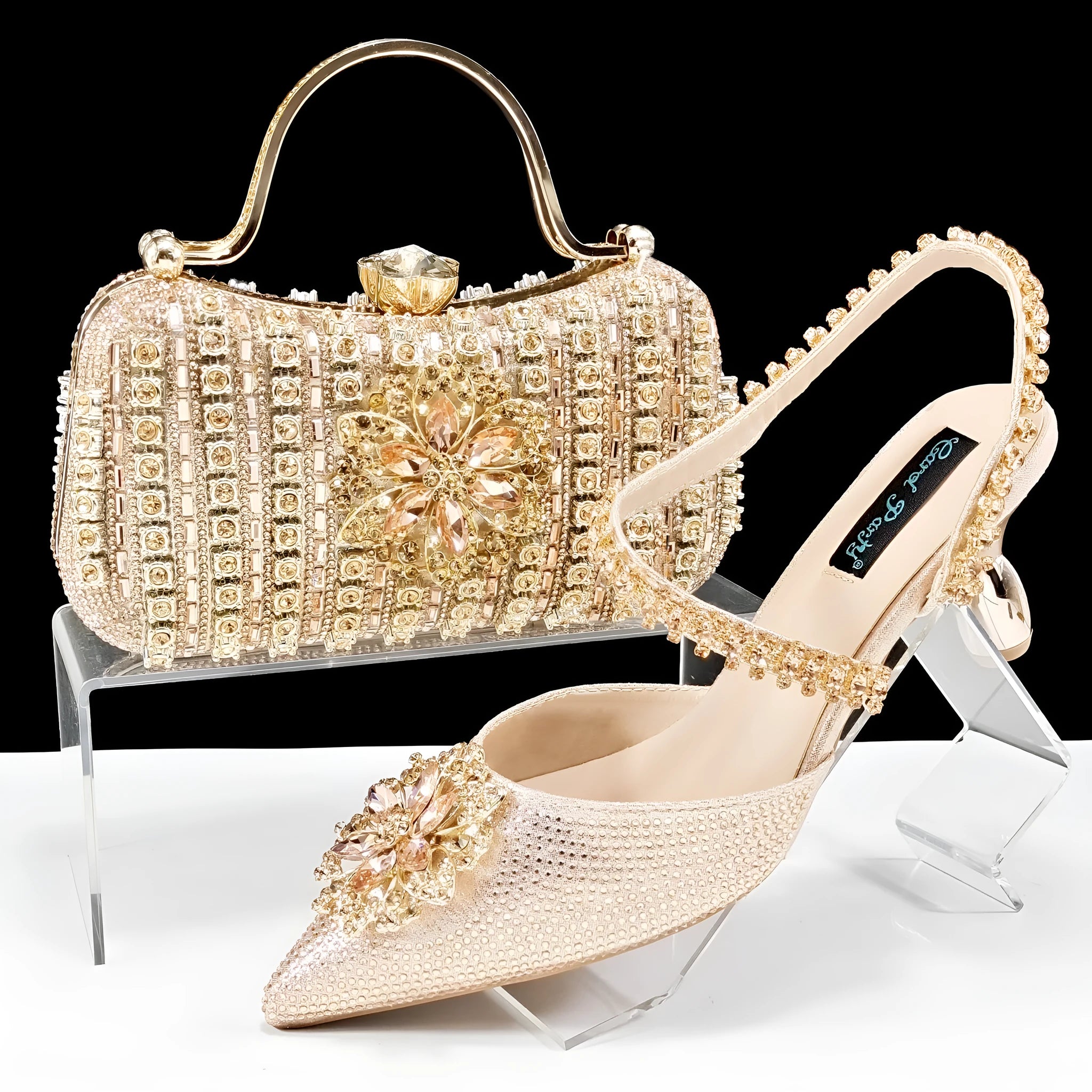 Women's black high heel and matching clutch bag set with floral decoration and rhinestones.