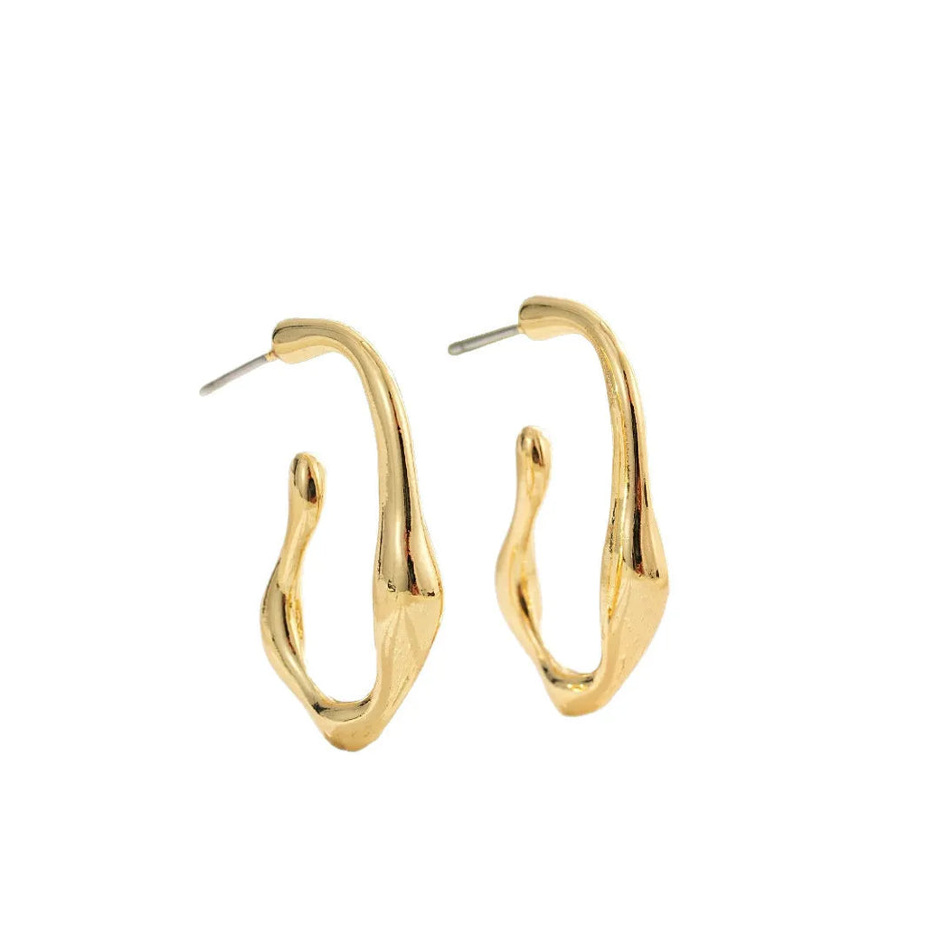 Irregular shaped minimalist drop earrings in gold tone on a clean background