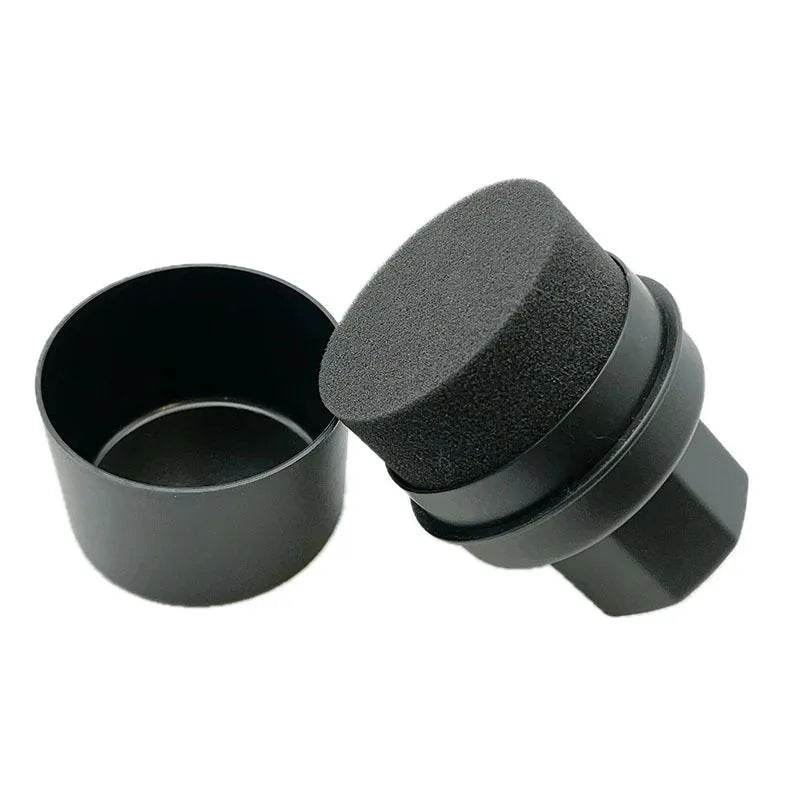 Black and red car tyre polishing sponge brushes with lids on a workbench.