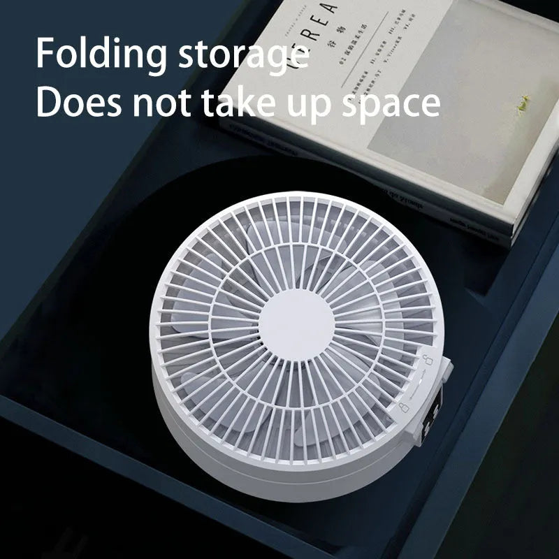 White portable folding electric fan with night light and remote control on a desk