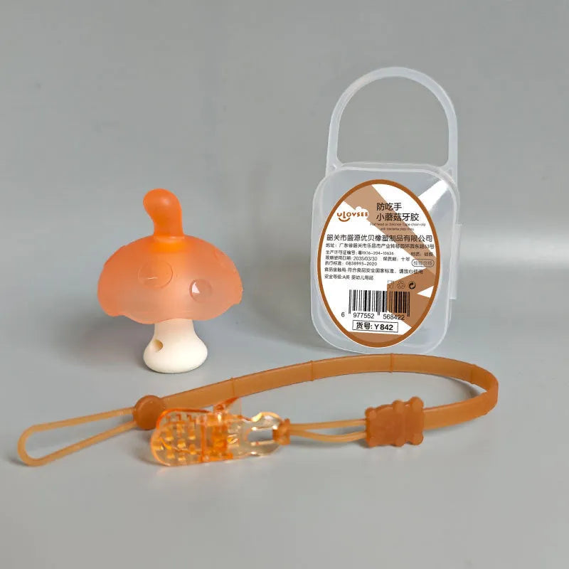 Small pink mushroom-shaped silicone chew on a transparent chain next to a clear storage box.