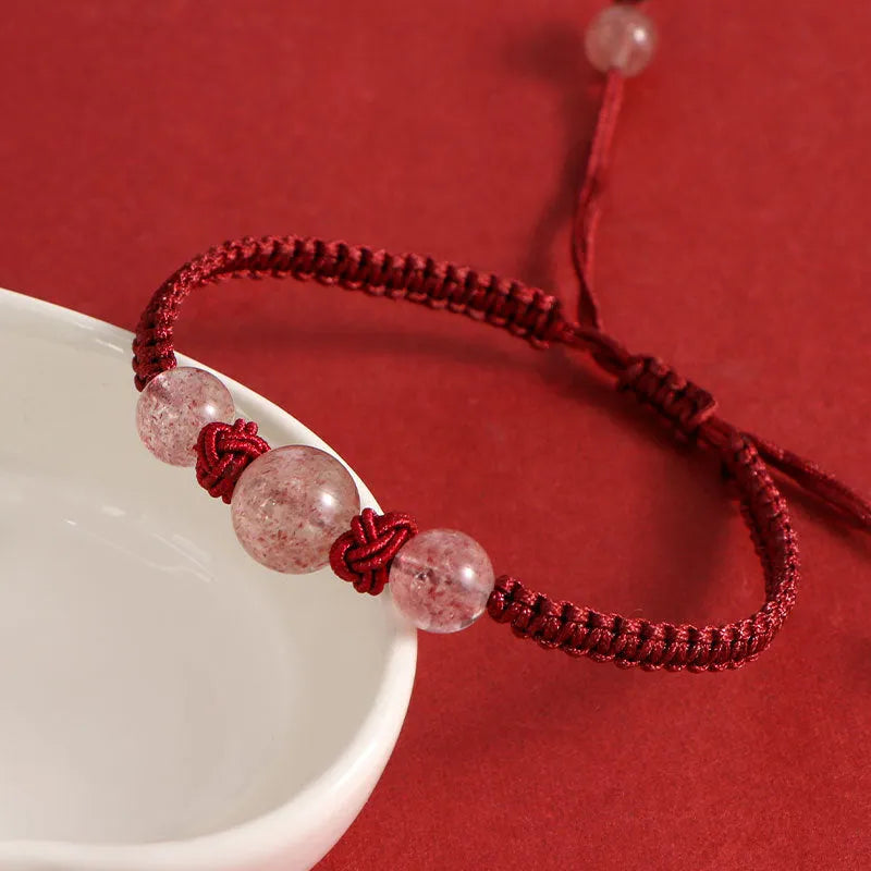 Woven red rope bracelet with alloy beads and natural strawberry quartz or obsidian stone beads