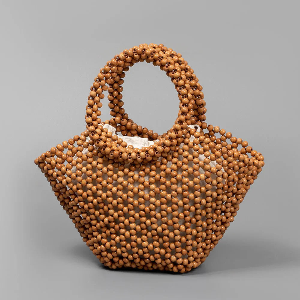 Hand-woven dumpling-shaped beach bag with wooden beads in milky white.