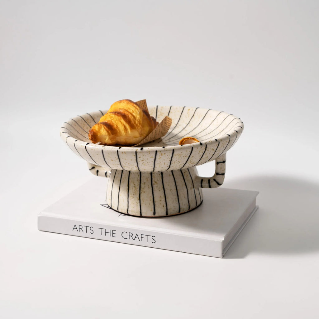 Black and white striped retro style synthetic resin fruit plate on a wooden surface.