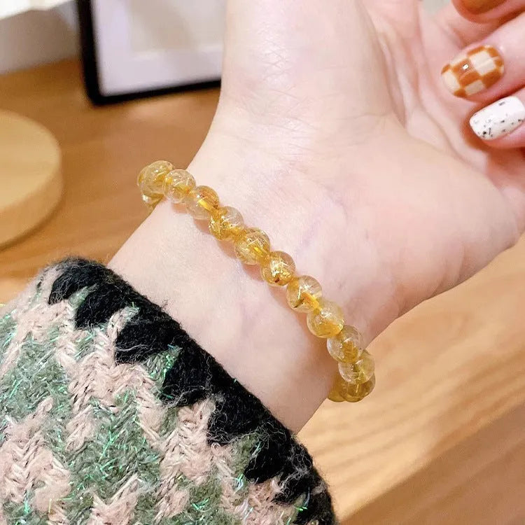 Gold rutilated quartz sunstone crystal bracelet with diamond-shaped beads for women.