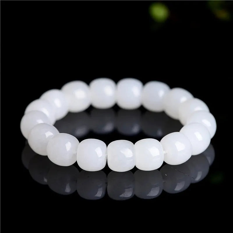 Handmade white Hetian jade barrel bead bracelet for men and women on a wrist.