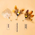 Three steel wire cat toys shaped like small flying insects on a plain background.