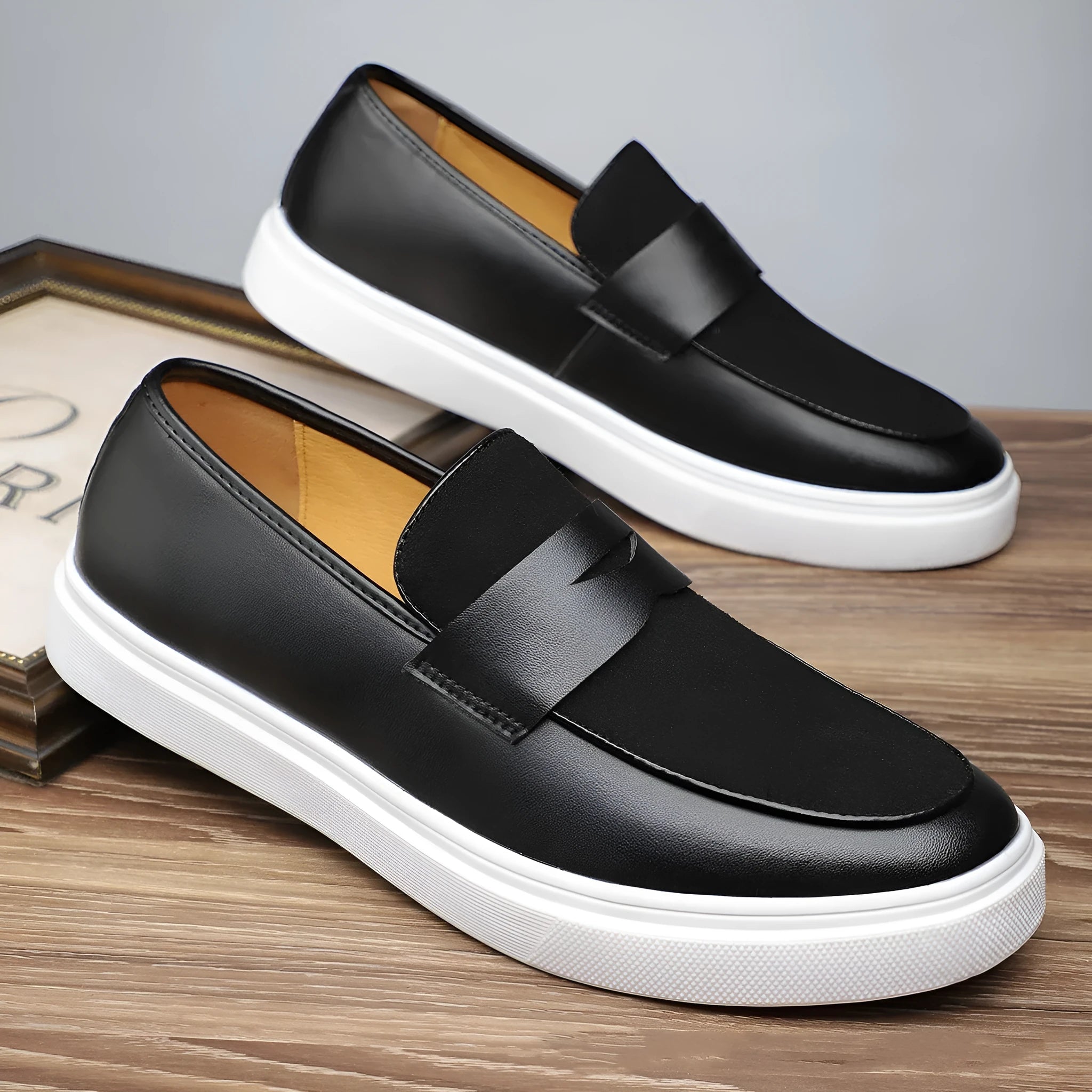 Black men's British-style slip-on casual shoes with a round toe and tassel detail on the upper.