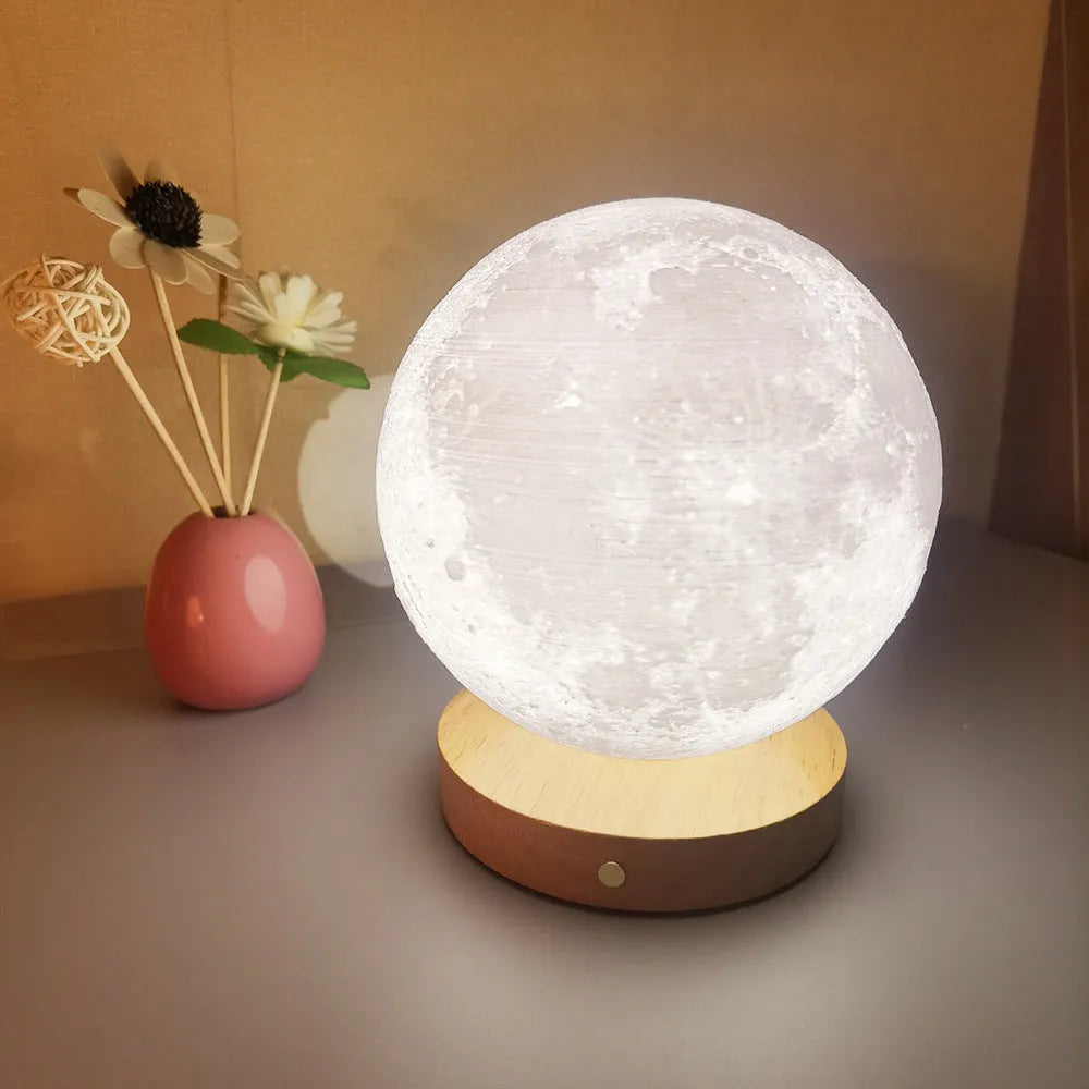 Rotating moon night light on wooden base showing three colour settings