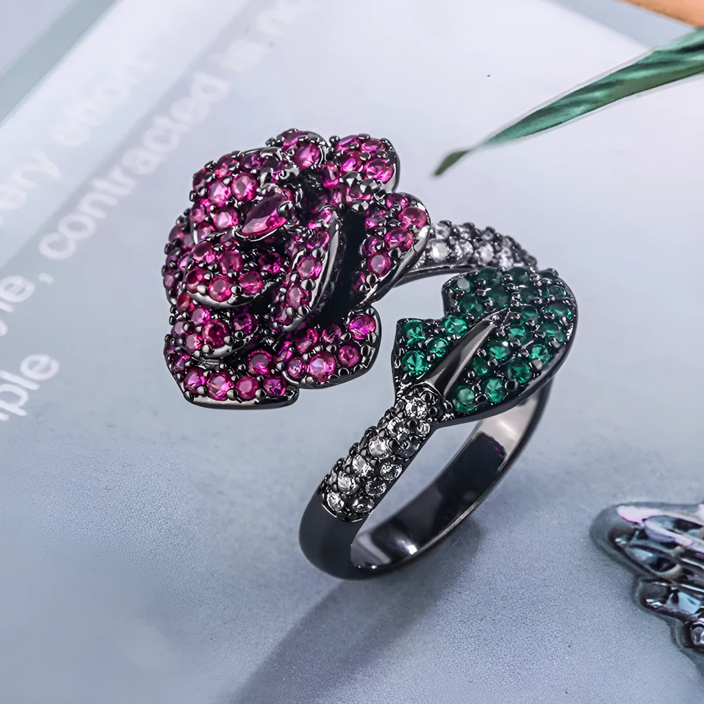 Geometric black gold plated ring with red simulated corundum stone in a floral setting.