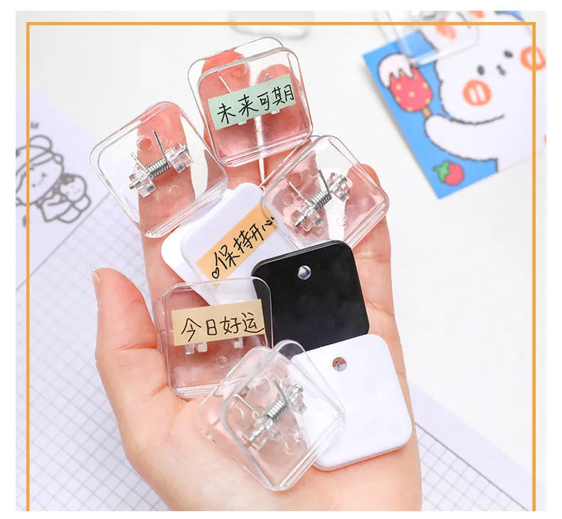 Small square plastic photo note holder in white, black and transparent colours on a desk