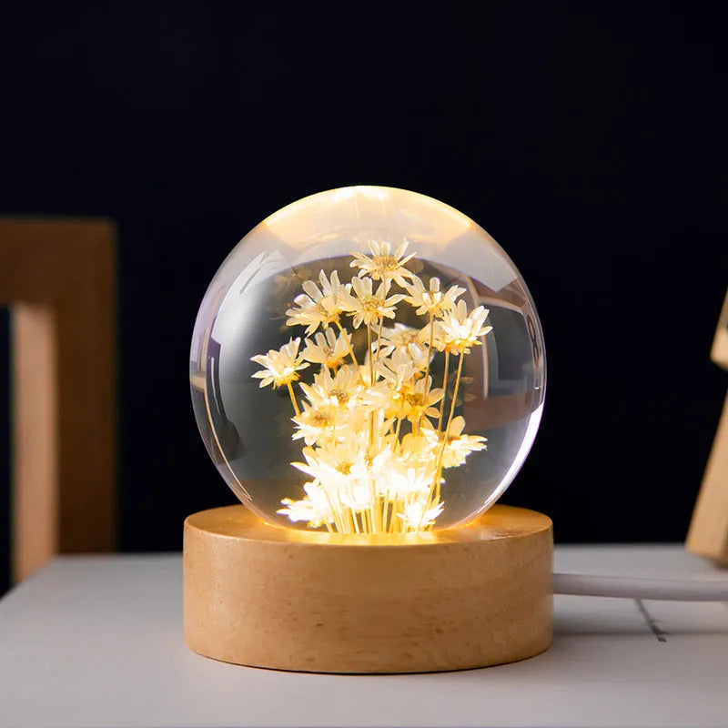 3D preserved dandelion inside clear resin ball LED lamp on beech wood desktop stand.
