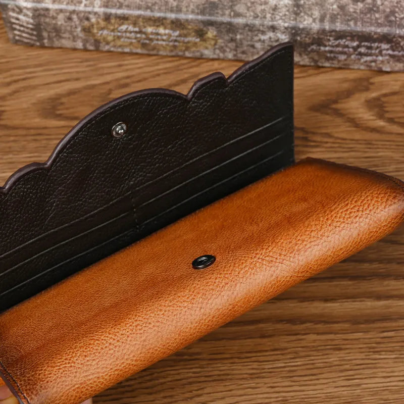 Retro brown embossed floral pattern tri-fold women's wallet made from genuine cowhide, shown open.