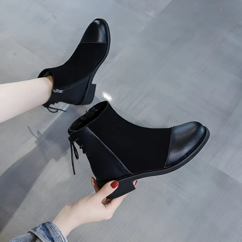 Black women's knee-high Martin boots with side zip, round toe, and block heel on a rubber sole.