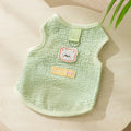 Cat wearing green knitted clothes with hollowed-out bear patch design