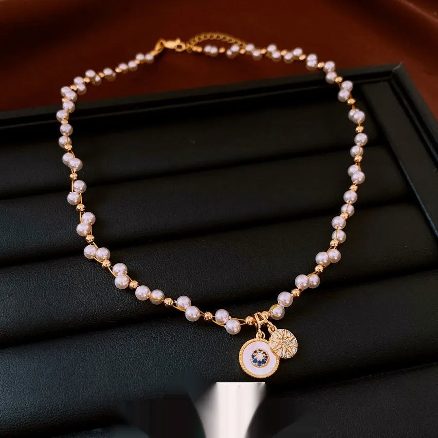Gold electroplated women's clavicle necklace with round zircon pearl pendant on white background