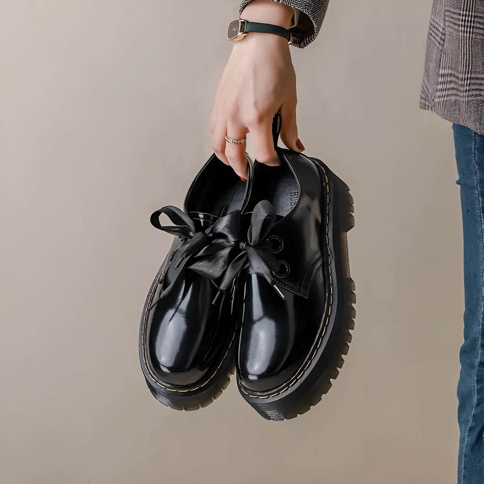 Women's black leather flat shoes with thick soles, cross straps, ribbons, and laced closure.