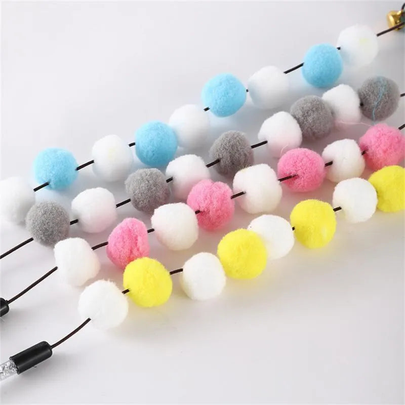 A blue acrylic cat teaser wand with pompon feathers and a bell, shown next to a grey and yellow version.