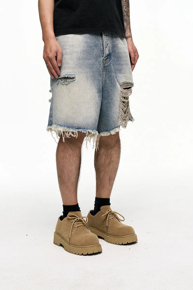 Men's light blue baggy denim shorts on a neutral background, showing wide leg and mid waist.