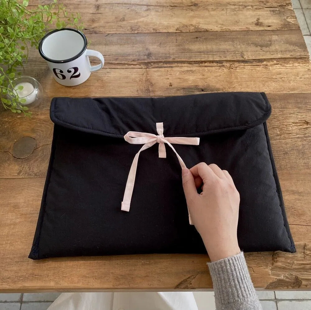 Women's quilted laptop bag with bow detail in nylon, showing striped lining and size options