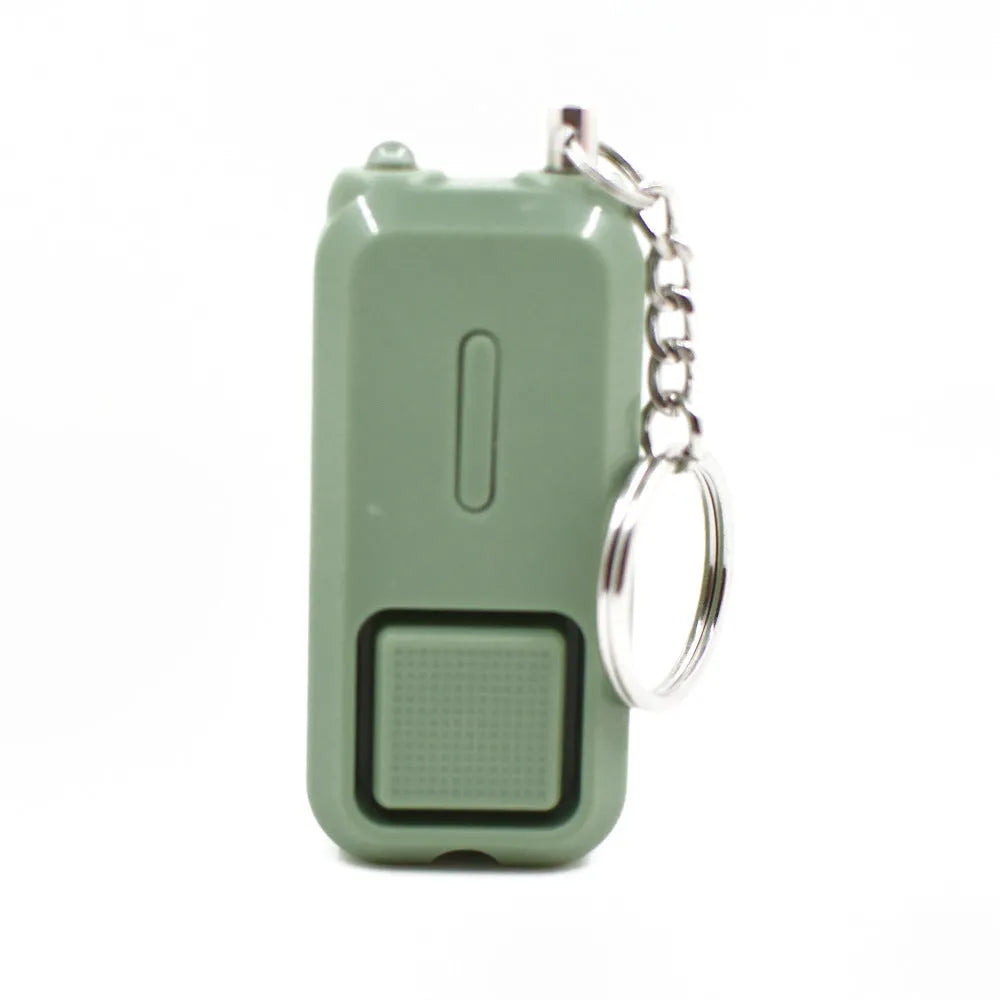 Small pink personal safety alarm on a keyring with a pull-pin activation mechanism.