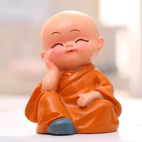 Set of 4 miniature resin Buddha monk statues in blue, brown, gray, and orange, 4.7 cm tall, on a shelf