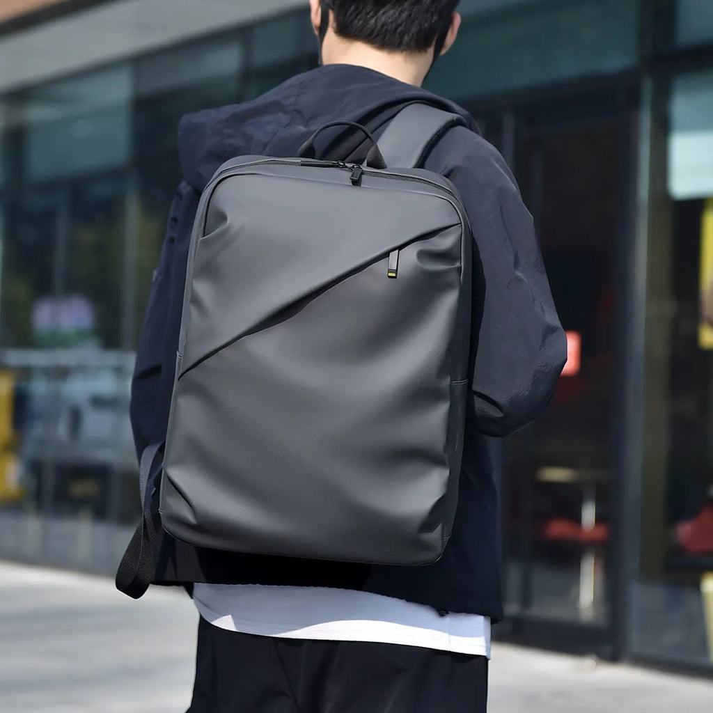 Waterproof PU leather backpack with laptop compartment in black, blue, and grey colour options