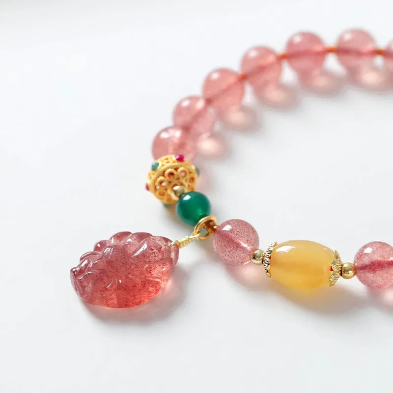 Women's crystal beaded bracelet with a strawberry quartz nine tail fox charm on a white background.