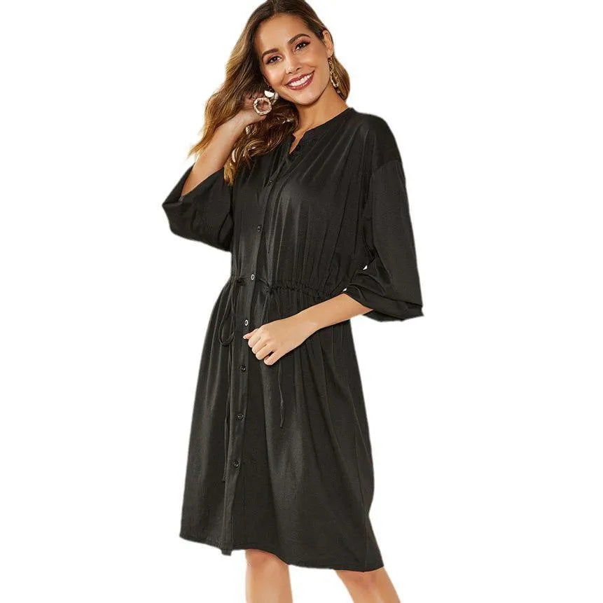 Women's black A-line midi dress with long sleeves, elastic cuffs, and a cinched elastic waist belt.