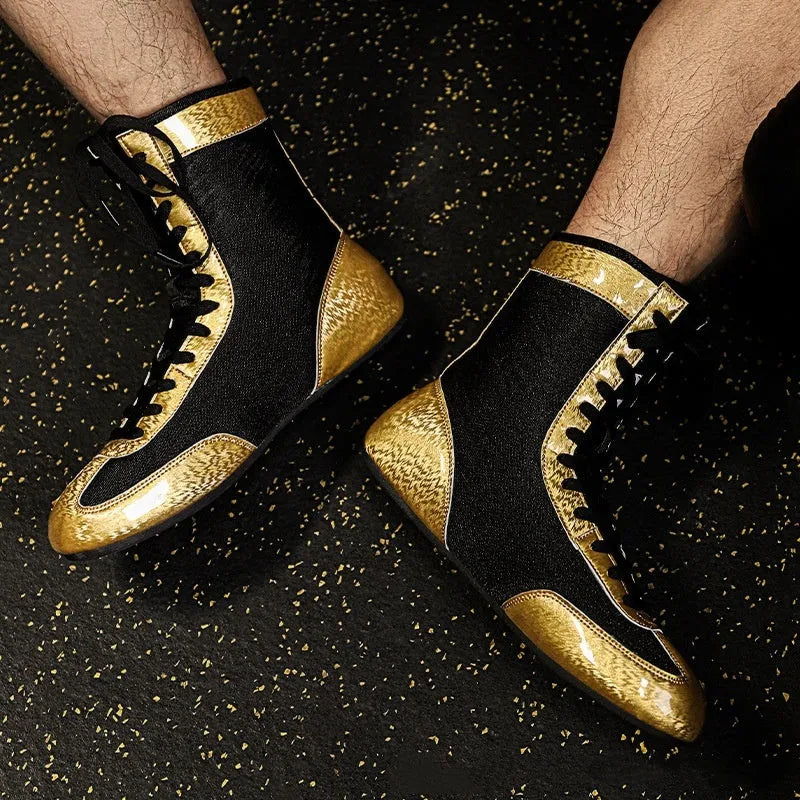 Black and gold mesh professional boxing shoes for men and women on a gym mat.