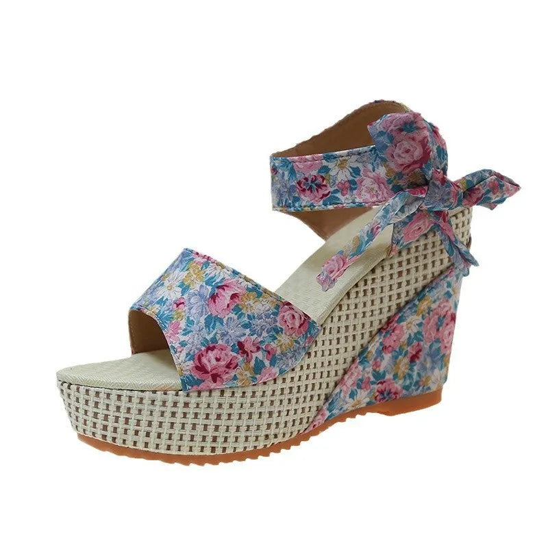 Women's floral patterned peep toe wedge sandals with an ankle strap buckle.