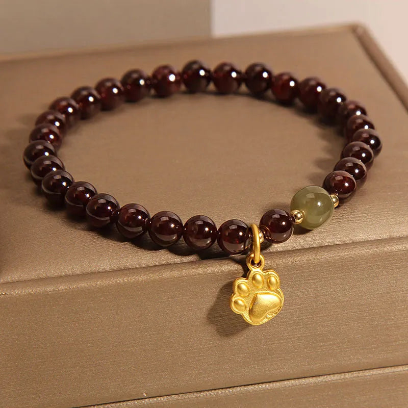 Women's original design Cat's Paw Garnet crystal bracelet on a plain background.