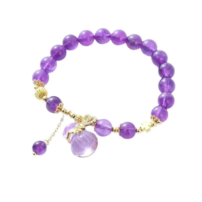 Purple crystal bracelet with ethnic money bag pendant and peace buckle closure on wrist