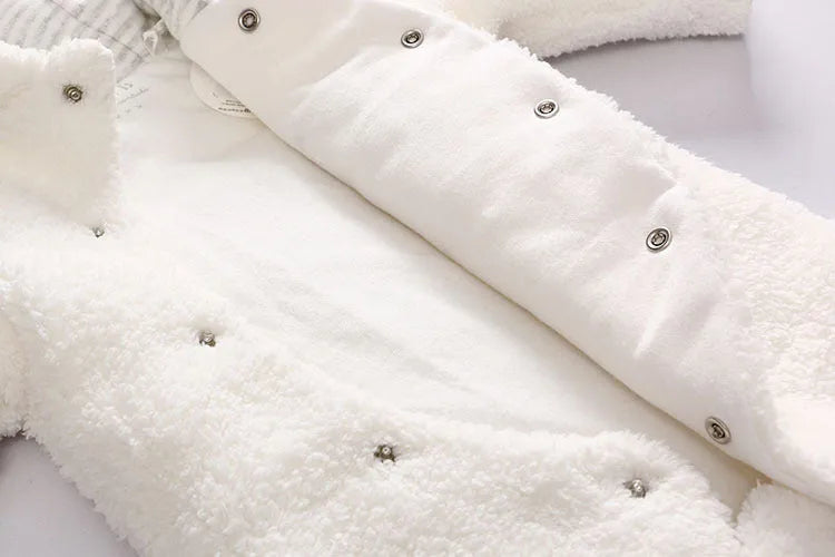 Baby wearing white cotton padded romper with lamb design and feet covers