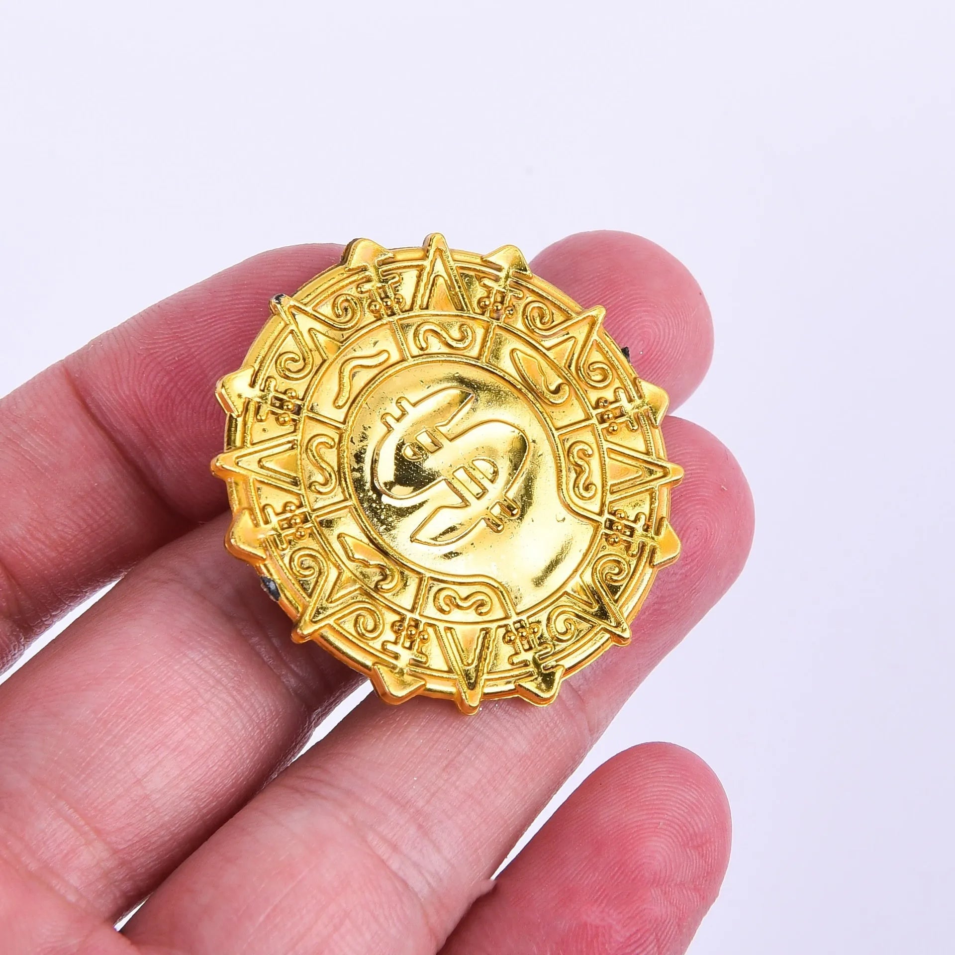 Gold plastic pirate coin with pointed edges measuring 3.6cm diameter for Halloween costumes
