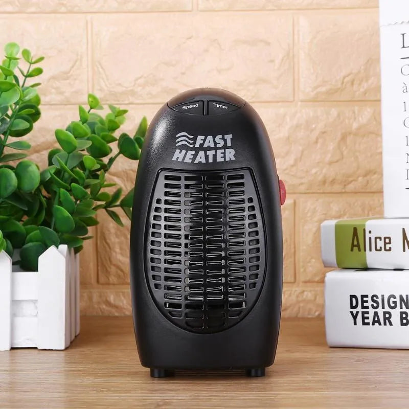 Black compact ceramic electric heater with digital display and a rotating plug on a desk.