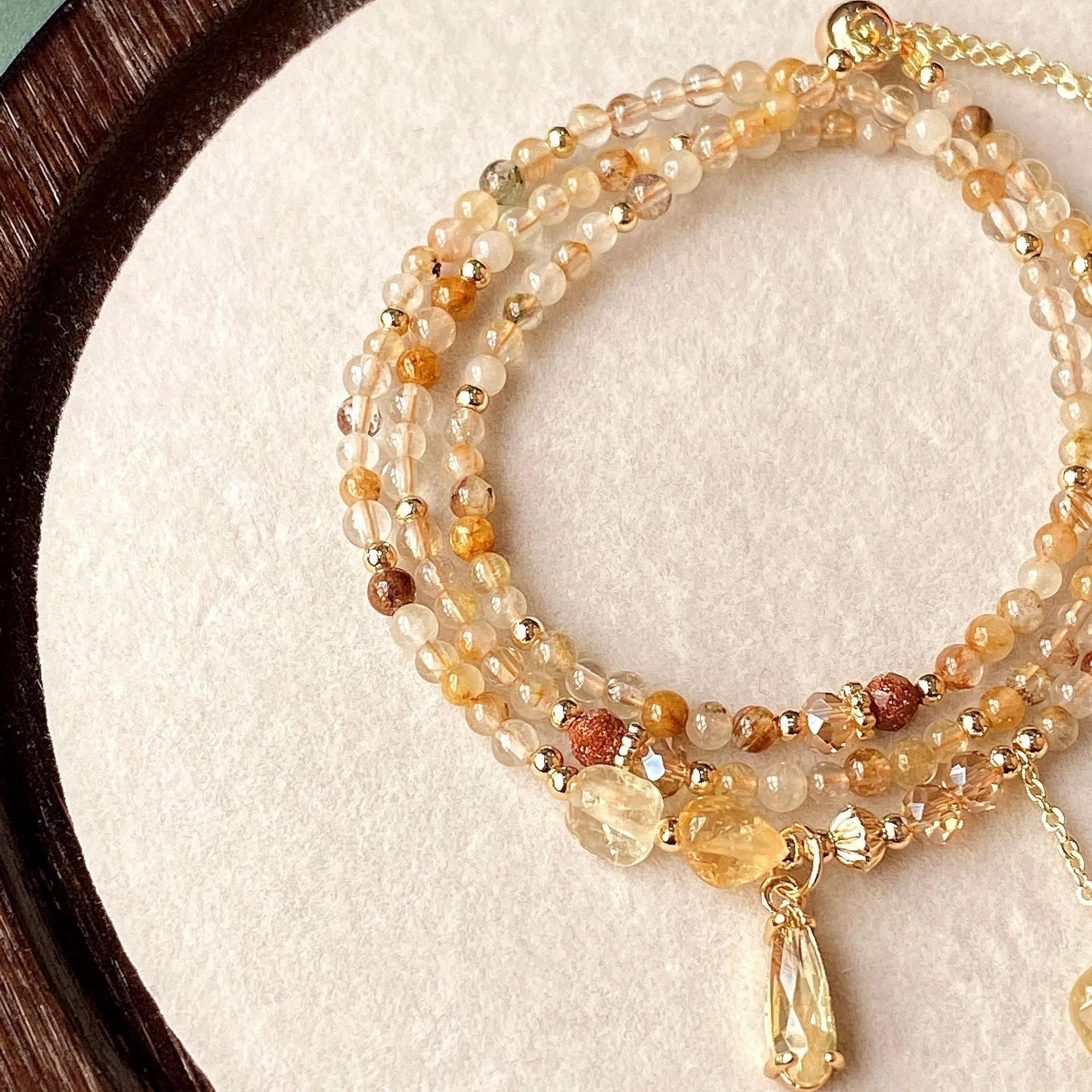 Women's gold natural citrine bracelet with three layered circles and Saturn design details.