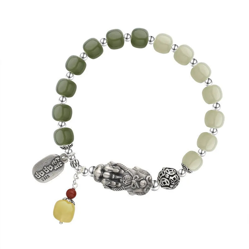 Handmade women's retro bracelet with a natural Hetian jade bead and pure silver coin charm on an adjustable chain.