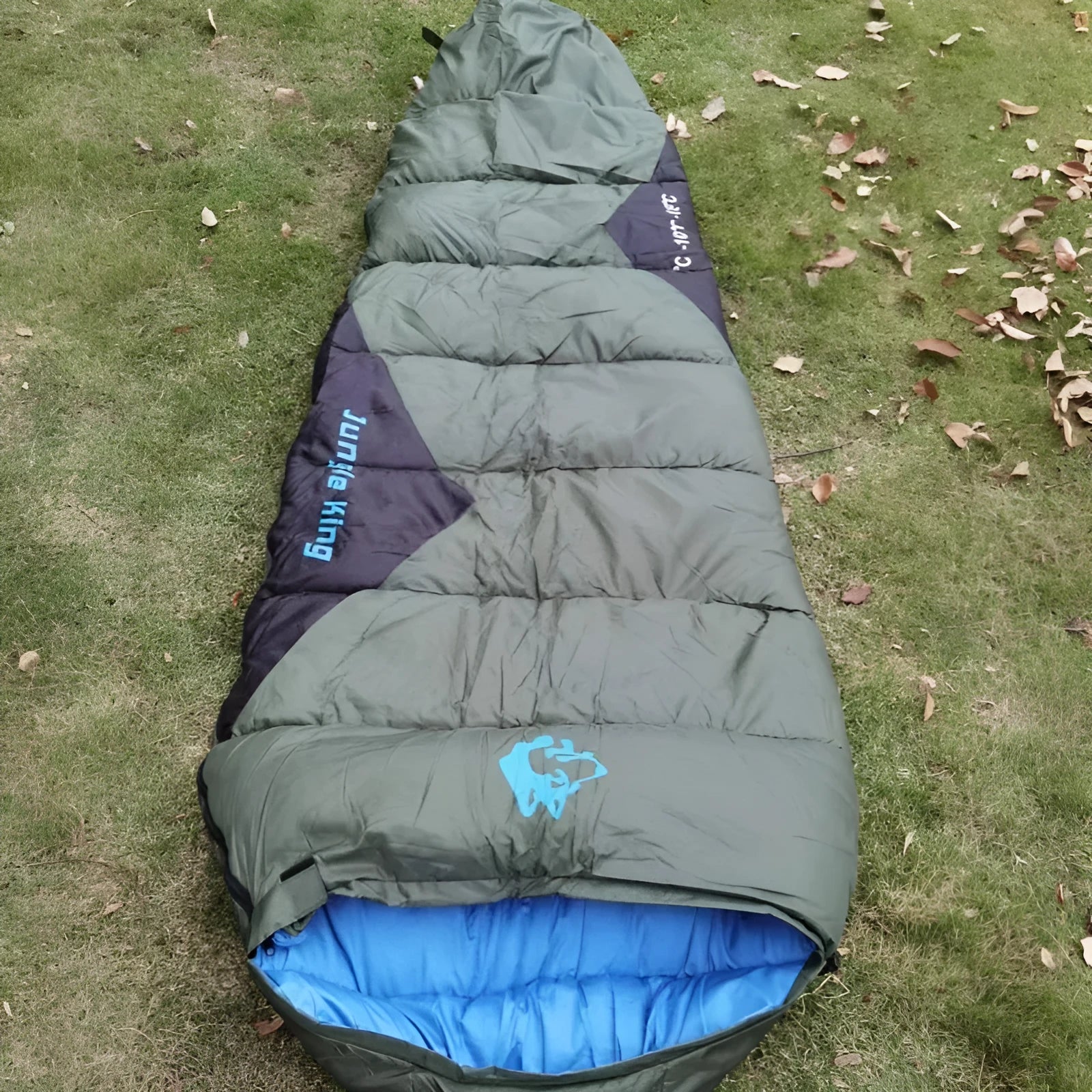 Outdoor cotton sleeping bag in army green with its compression storage sack.