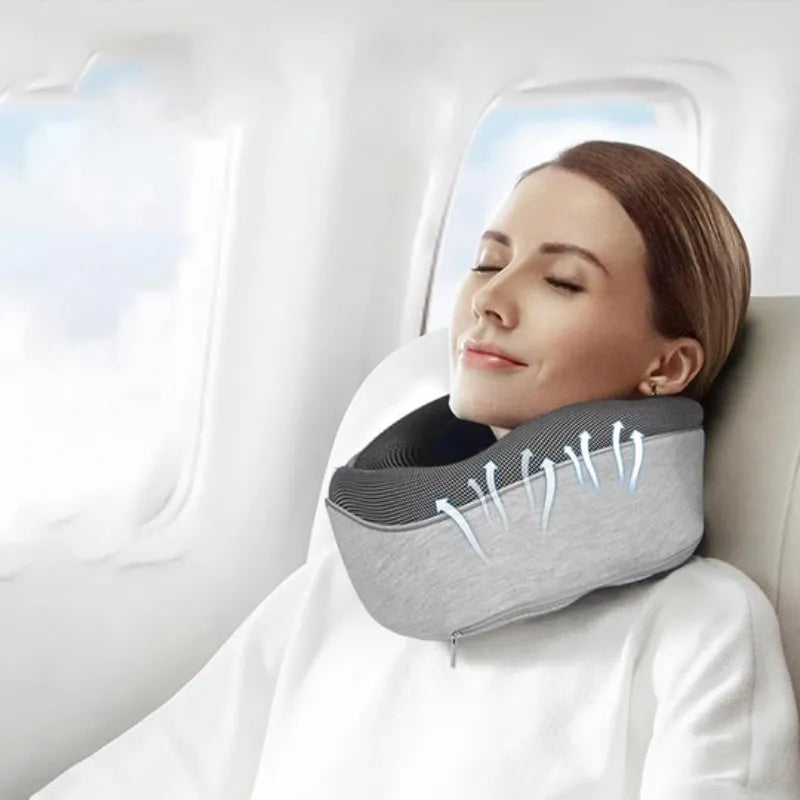 U-shaped navy blue memory foam travel neck pillow rolled up next to a mobile phone showing compact size