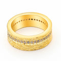 Geometric gold-colour copper ring with zircon stone on a grey background.
