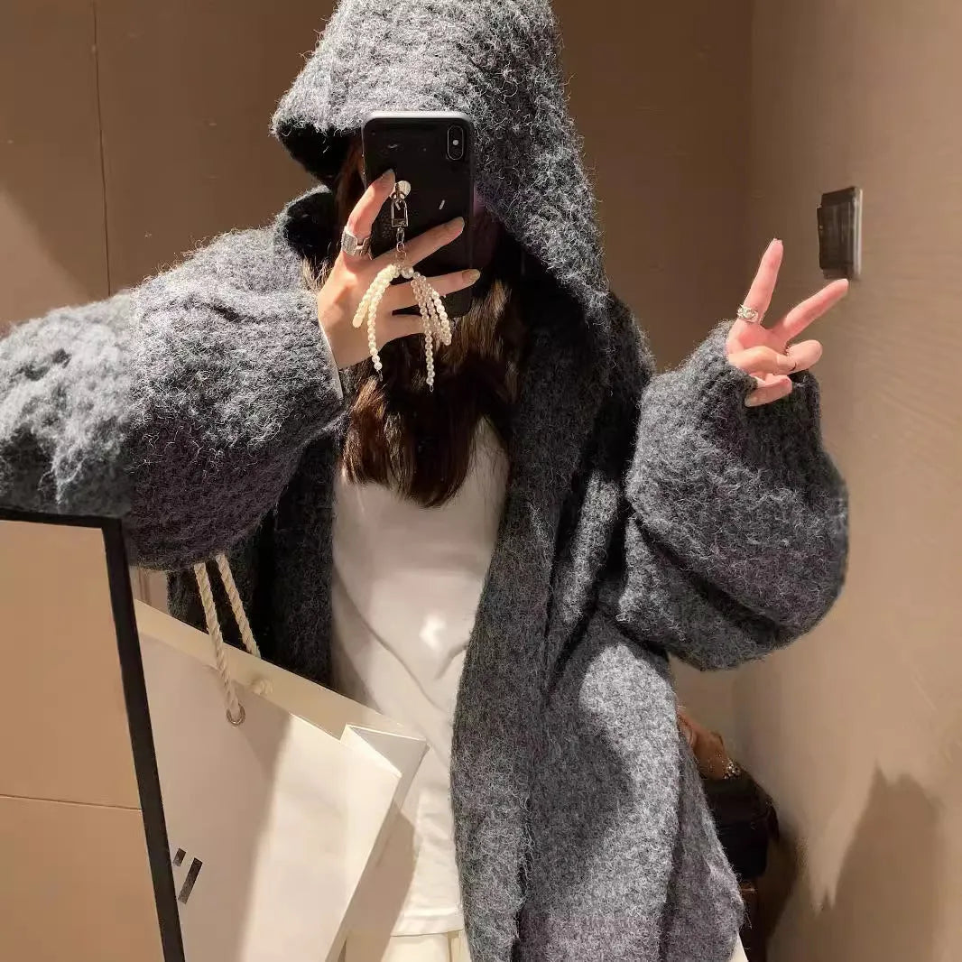 Brown women's hooded sweater cardigan with thick knit and loose fit on a hanger.