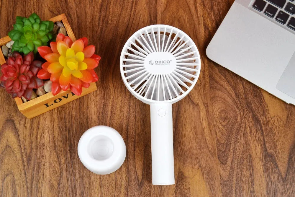 White ORICO FH1 portable USB rechargeable small fan on a desktop.