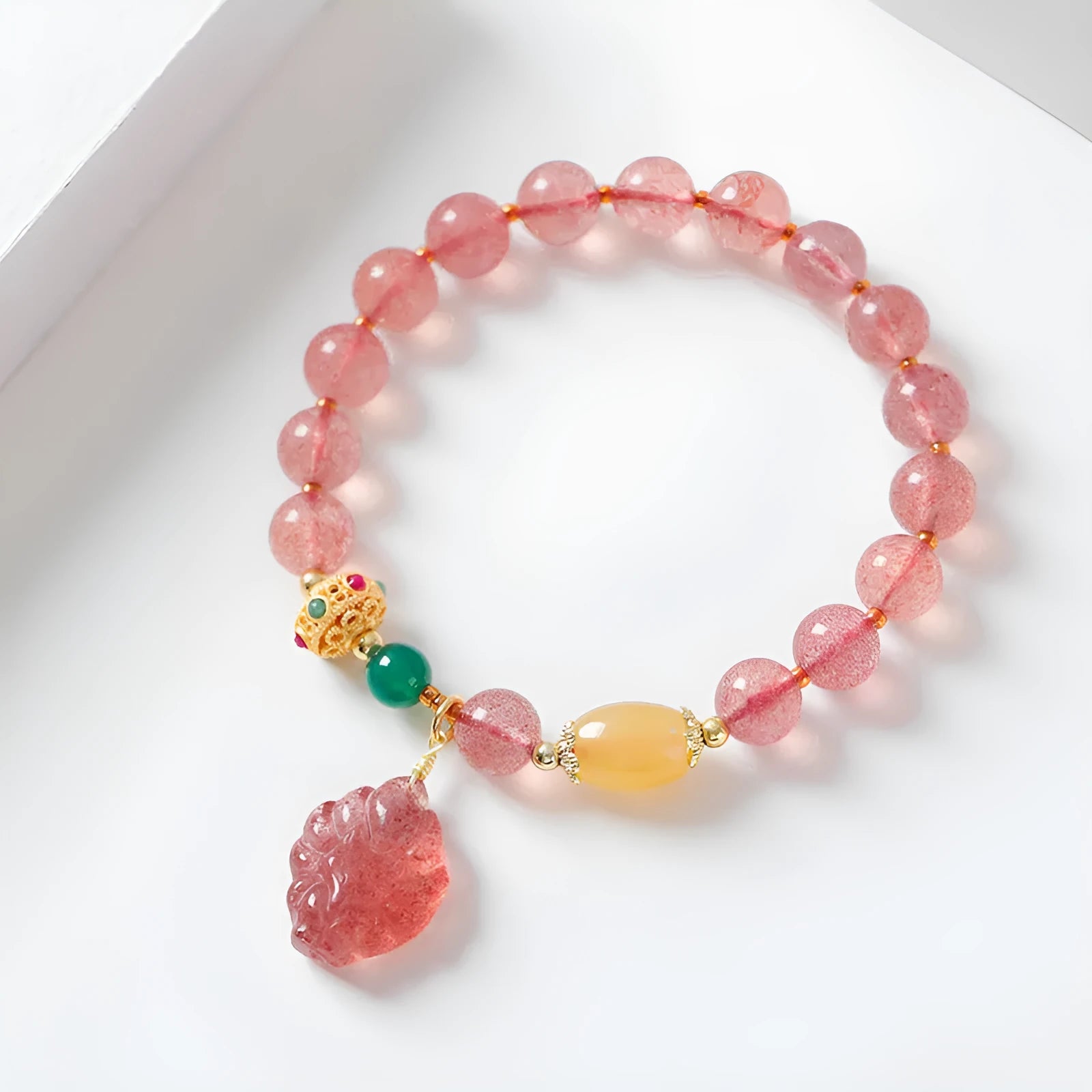 Women's crystal beaded bracelet with a strawberry quartz nine tail fox charm on a white background.