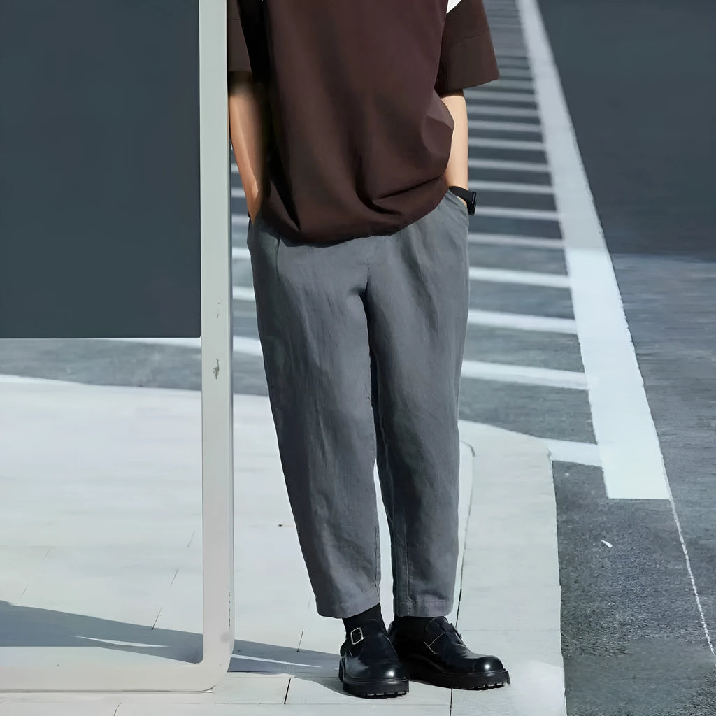Man wearing beige loose straight-leg casual summer pants with a drawstring waist.