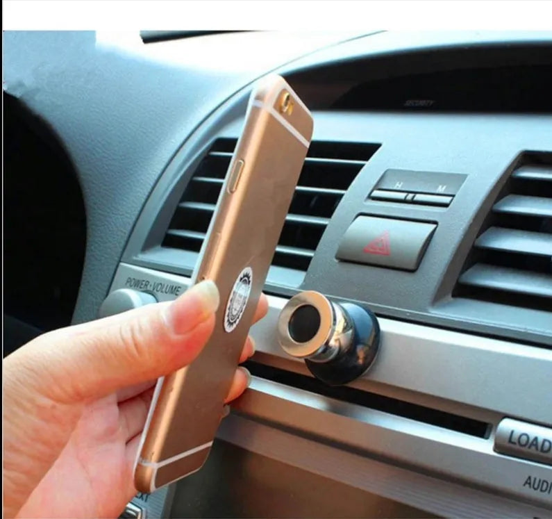 Magnetic car phone holder in black with alloy metal construction on car dashboard