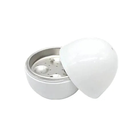 White microwave egg cooker with capacity for four eggs on a kitchen counter.